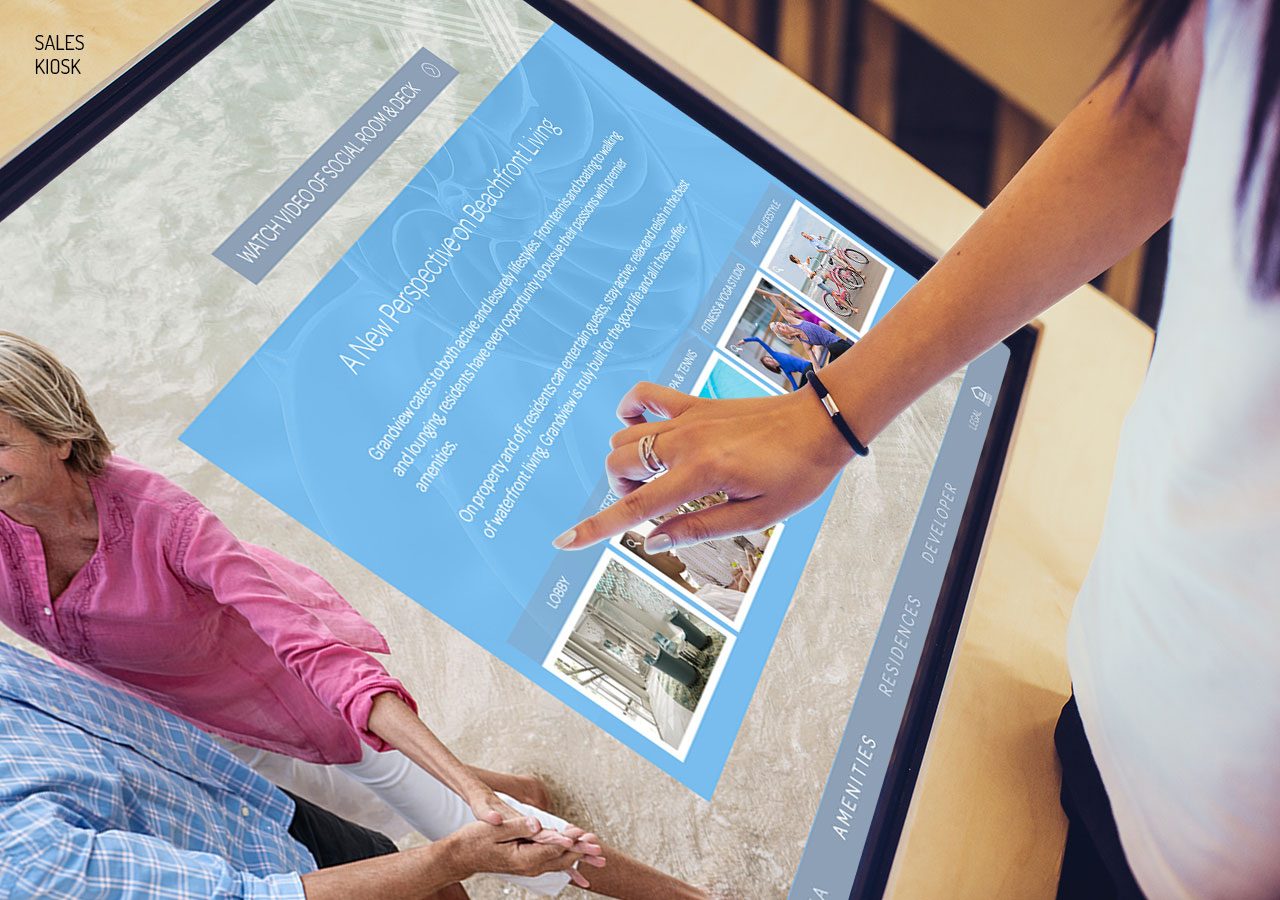 People interacting with a large touchscreen displaying images and text in an indoor setting.