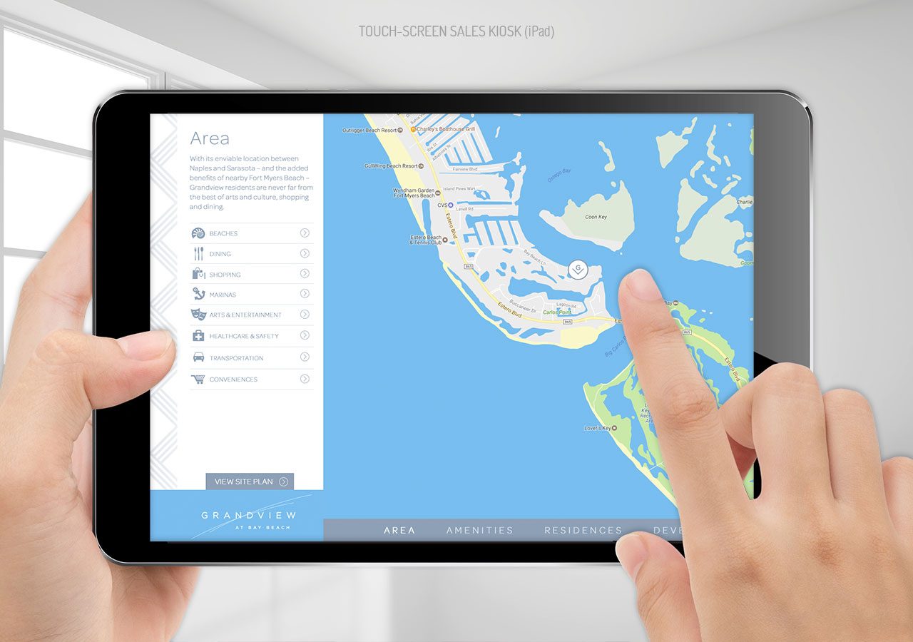 A person using a tablet to navigate a digital map of a coastal area with labeled locations and routes.