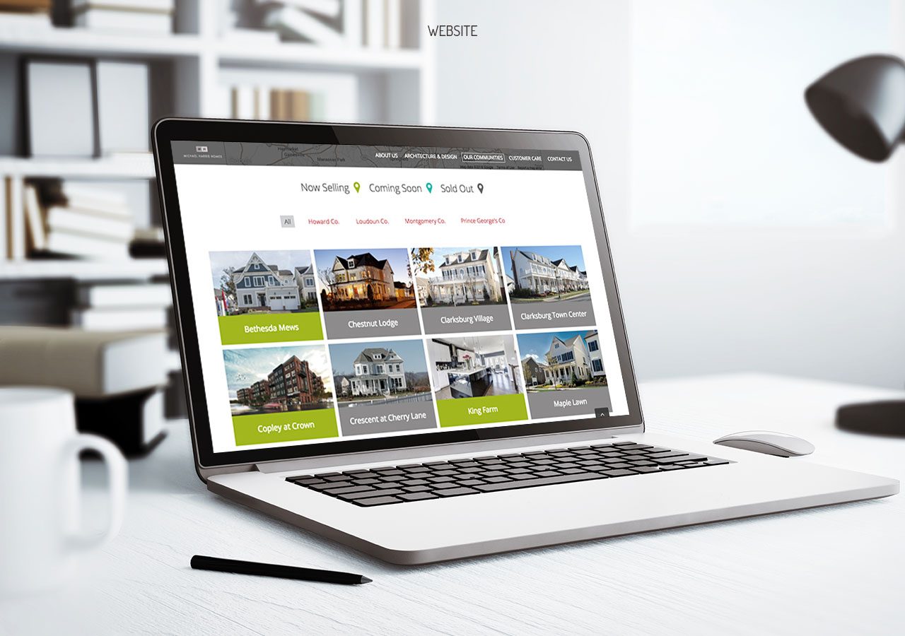 A laptop displaying a real estate website with property listings and a pen placed beside it on a desk.