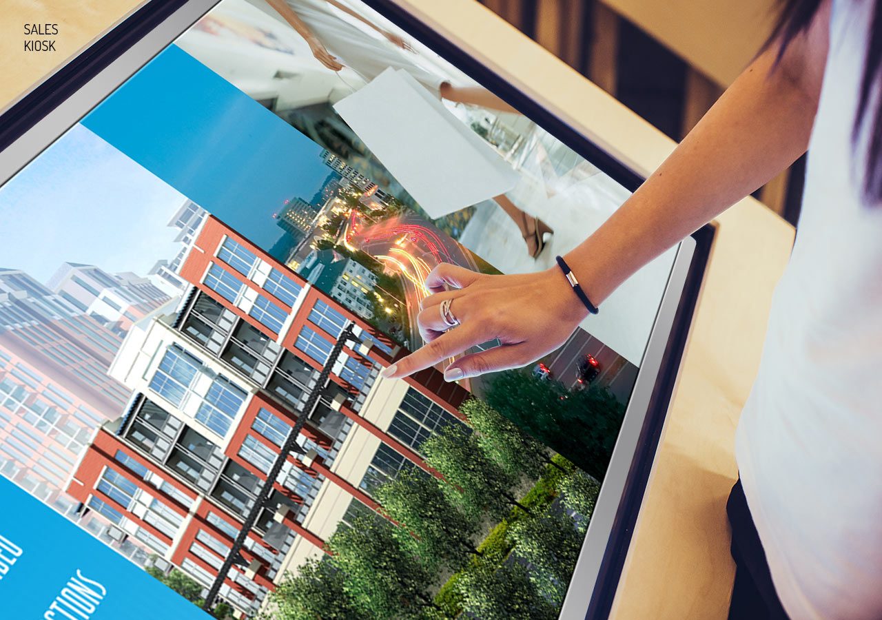 A person holding a small transparent cube reflecting a building and greenery on a glass surface.
