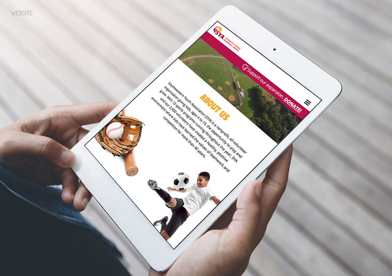 A person holding a tablet displaying a webpage with images and text about a couple and a wooden puzzle piece.