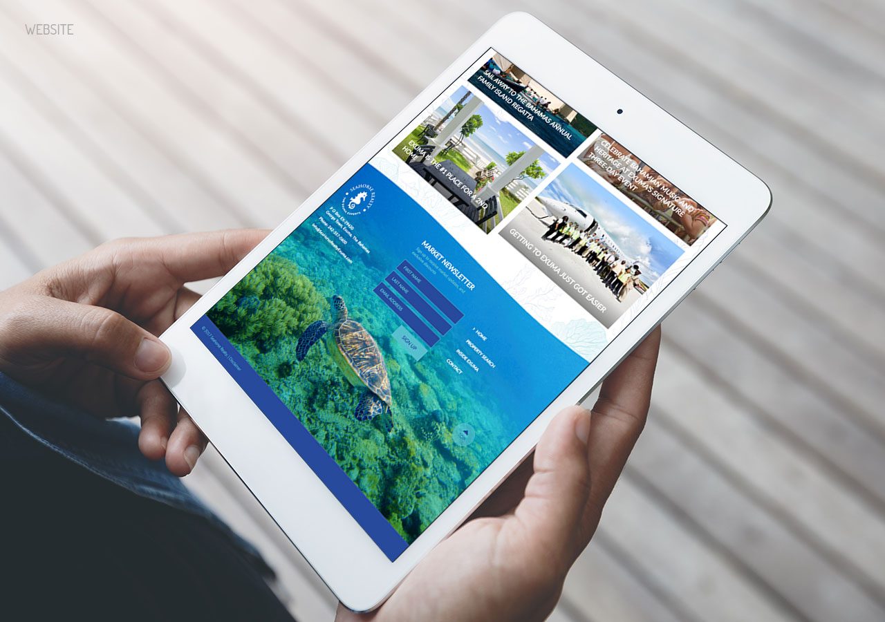 Person holding a white tablet displaying a travel website with images of destinations and ocean views.