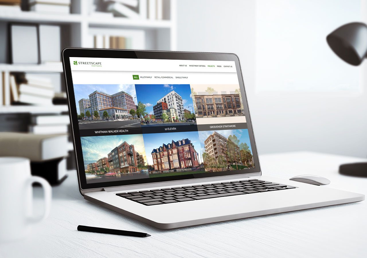 A laptop displaying a real estate website with various property listings and images.