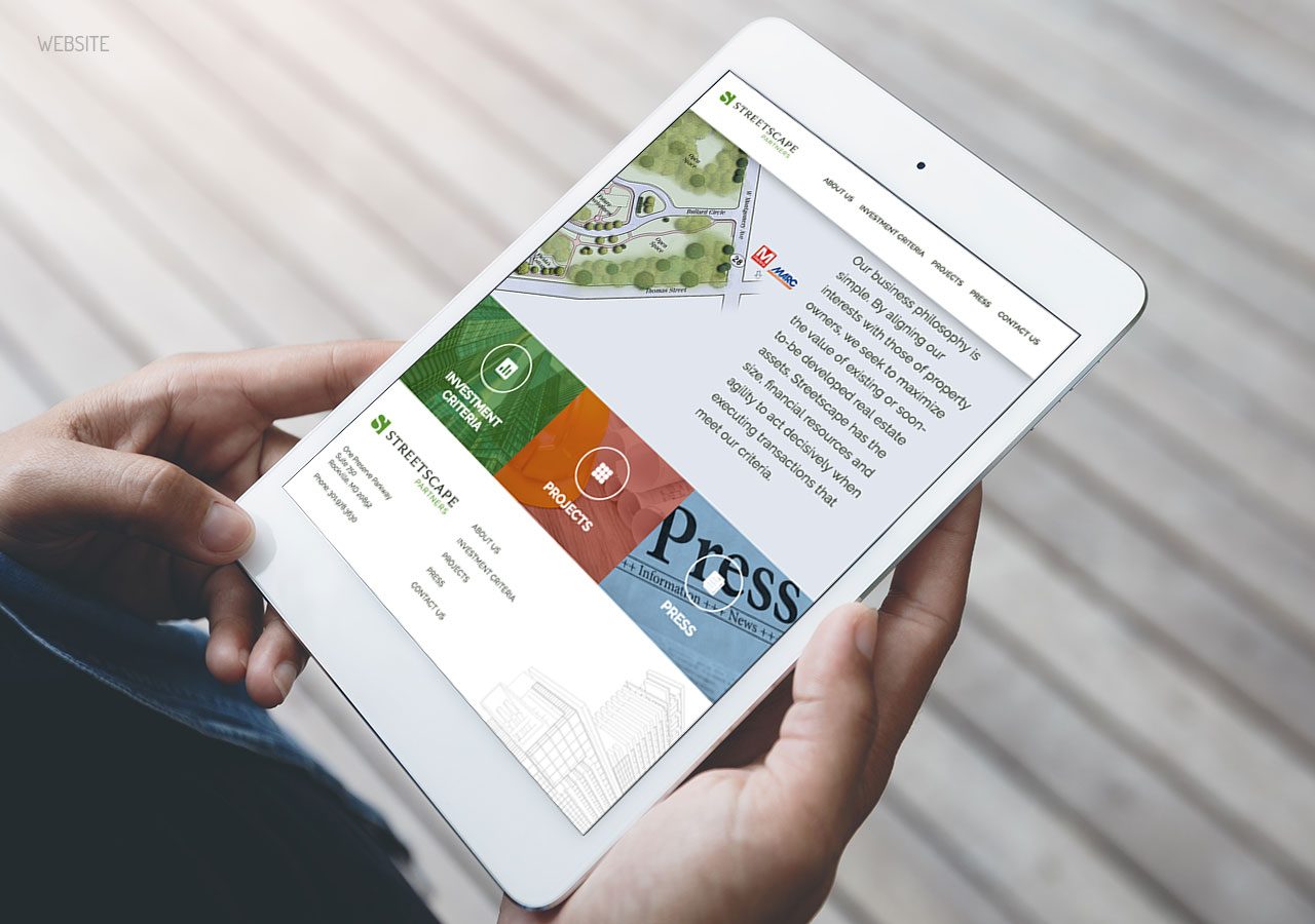 Hands holding a white tablet displaying a colorful website with sections labeled 'Video,' 'Press,' and 'Contact'.