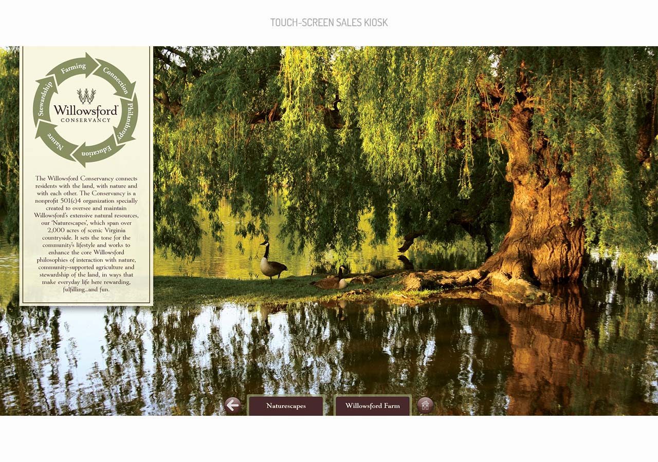 A serene riverside scene with a large willow tree and lush greenery reflected in calm water.